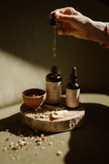 Bottles of Oil&Ohm Kapha Balancing Body Oil with hand dripper